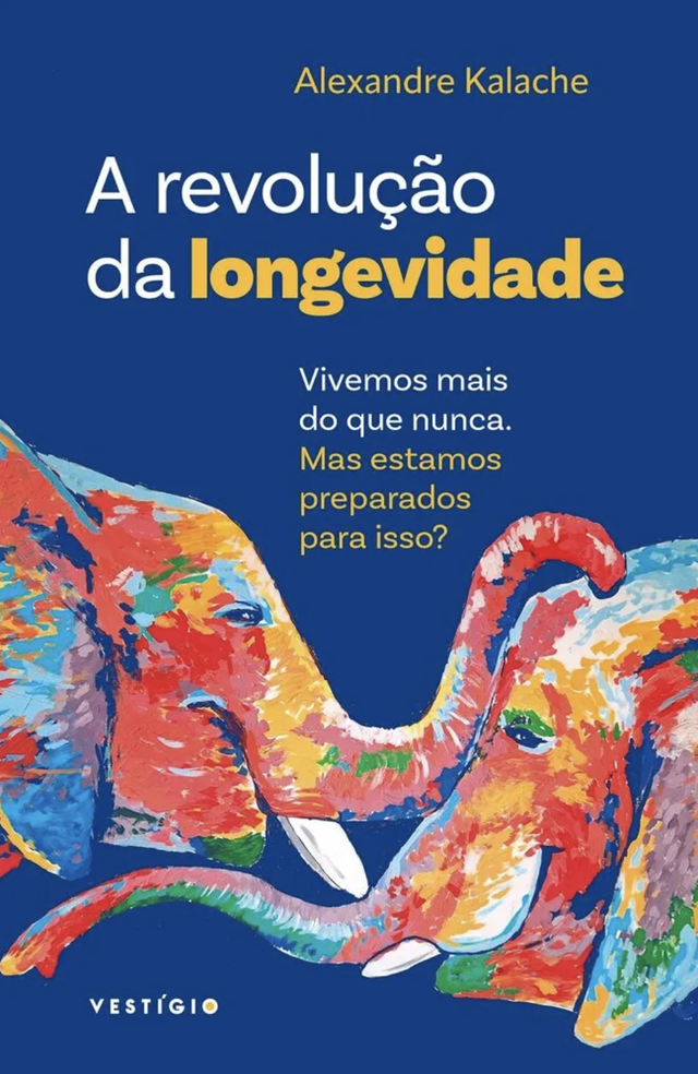 The image is the cover of a book titled "A revolução da longevidade" by Alexandre Kalache. The cover features a blue background. Two elephants are depicted in a colorful, painterly style, their trunks intertwined. The book's text includes the phrases "Vivemos mais do que nunca. Mas estamos preparados para isso?" ("We live longer than ever. But are we prepared for this?"), with the word "VESTÍGIO" also prominently displayed.